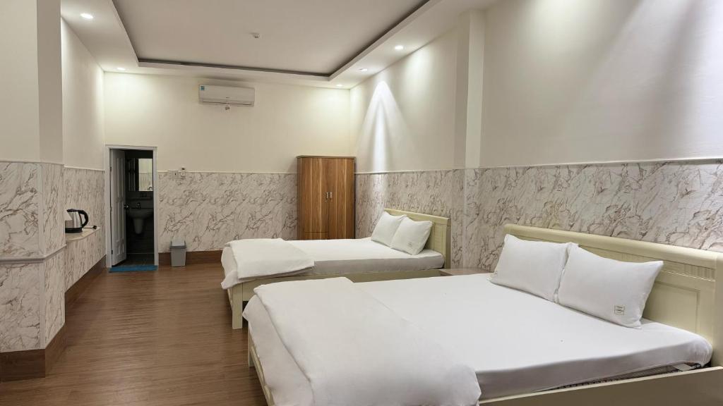 ein Hotelzimmer mit 2 Betten und einem Bad in der Unterkunft AT Hotel Cần Thơ in Ấp An Mỹ