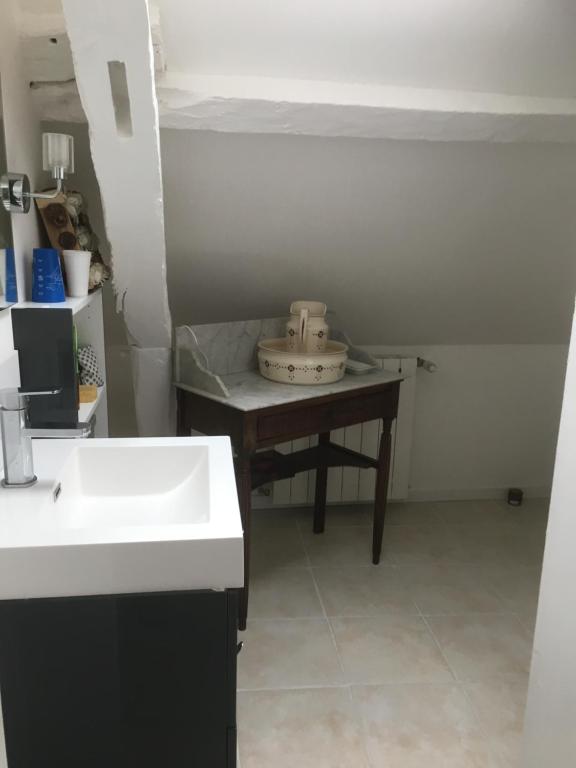 a kitchen with a sink and a table with a bowl on it at Chambres de la Choisille à Fondettes st Cyr Tours in Fondettes
