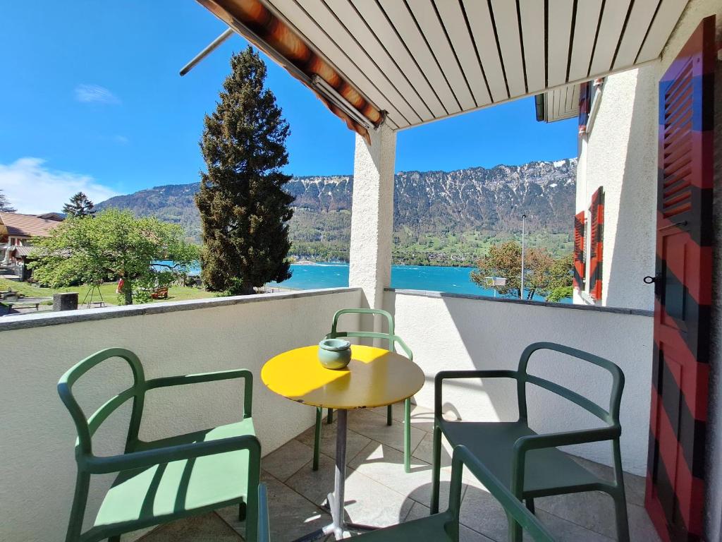 einen Tisch und Stühle auf einem Balkon mit Aussicht in der Unterkunft Lake House in Bönigen
