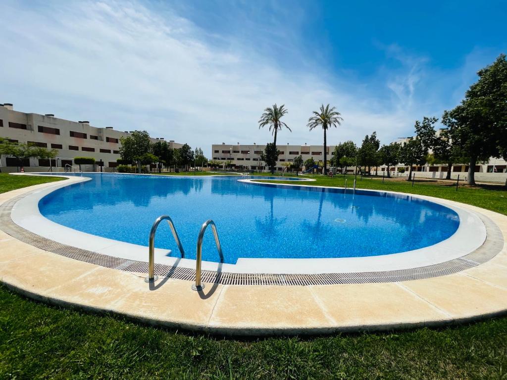 ein großer Swimmingpool in einem Park mit Palmen in der Unterkunft Apartamento Panoramica Golf - Sant Jordi in San Jorge