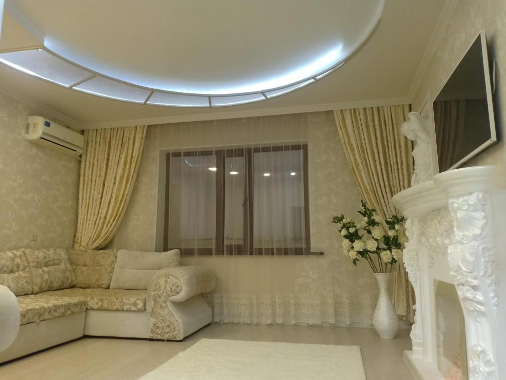 a living room with a couch and a vase of flowers at 3-комн. апартаменты в районе Болашак in Qyzylorda
