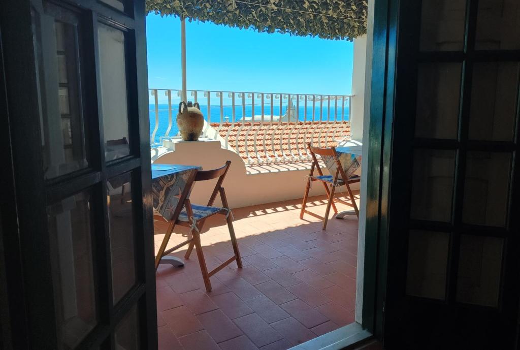 una camera con tavolo e sedie e vista sull'oceano di B&B Ventura a Città di Lipari
