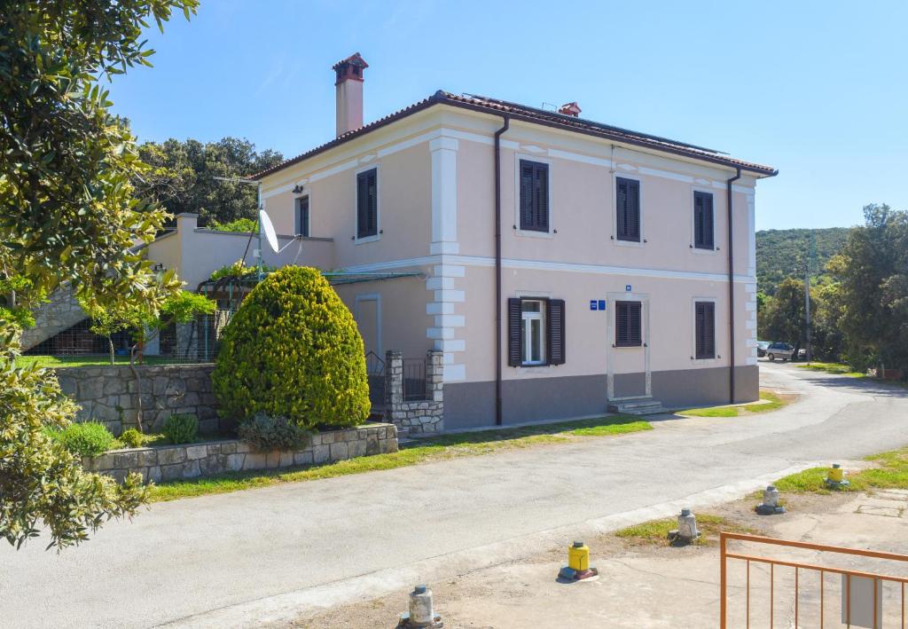 a white house with a chimney on top of it at Apartmani Županić in Koromačno