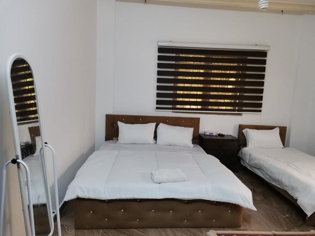 a bedroom with a large bed and a window at Flower 2 in Jerash