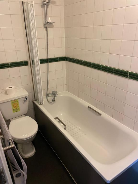 a bathroom with a toilet and a bath tub at The Olde Swan Hotel in Chertsey