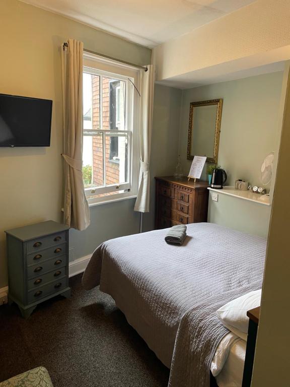 a bedroom with a bed and a window at The Olde Swan Hotel in Chertsey