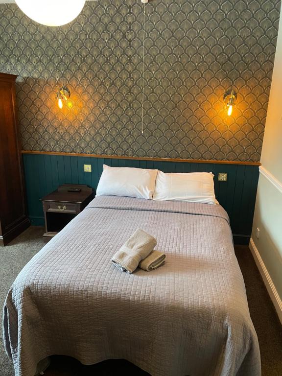 a bedroom with a bed with two towels on it at The Olde Swan Hotel in Chertsey