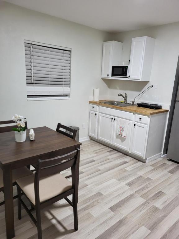 a kitchen with white cabinets and a wooden table at Seeing Busch Gardens from two apartments in Tampa
