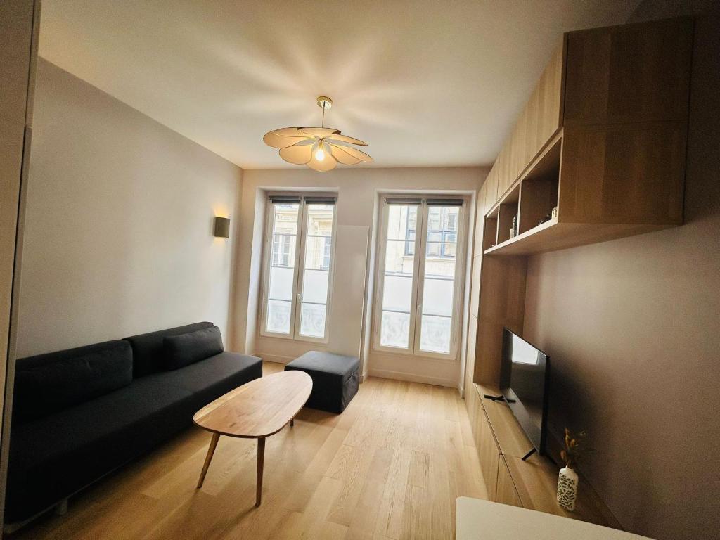 un salon avec un canapé et une table dans l'établissement Enghien - New studio fully furnished, à Paris