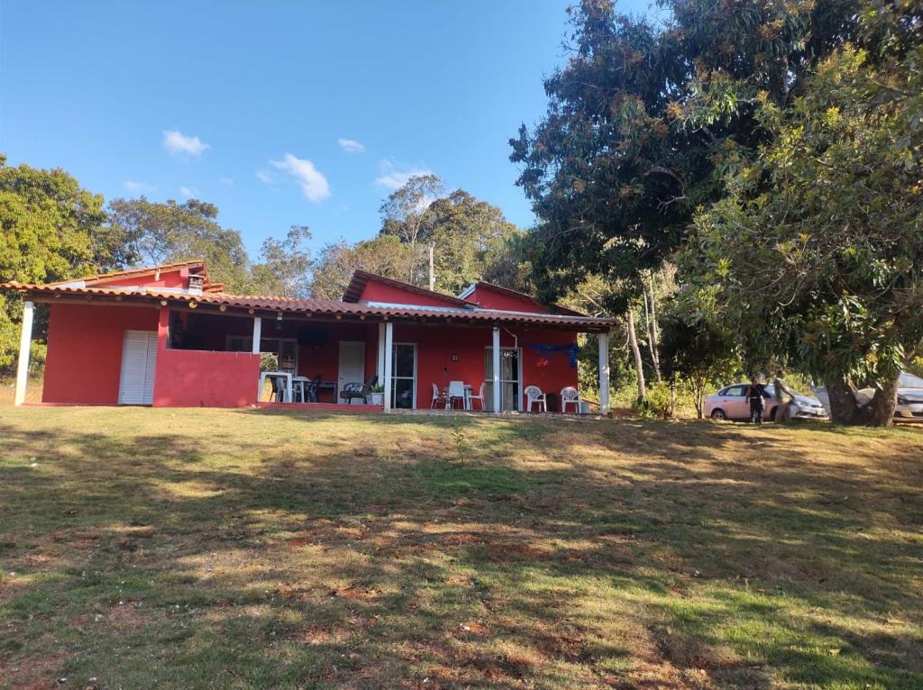 una casa roja con césped delante en CHALÉS MARICOTA, en Vargem Bonita
