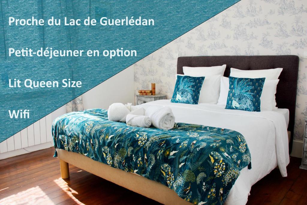 a bedroom with a large bed with blue and white sheets at Valfrescos - Lac de Guerlédan in Caurel