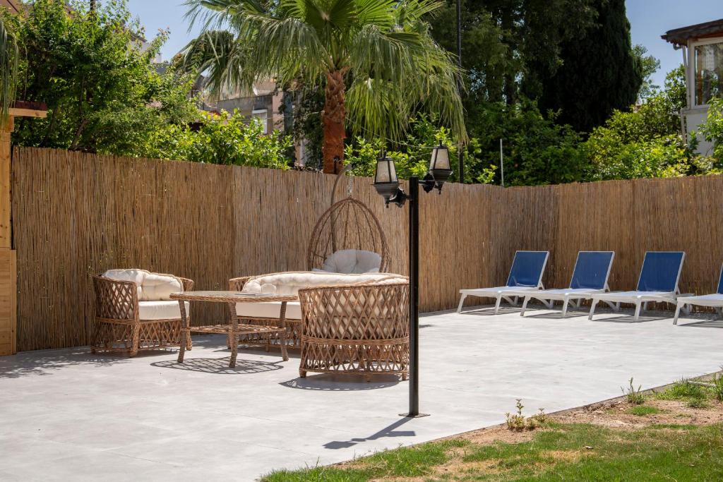 een patio met een tafel en stoelen en een hek bij My Hotel in Antalya