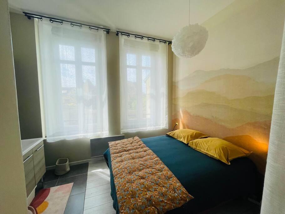 una camera da letto con un letto in una stanza con finestre di Emplacement idéal Confort et tranquillité a Boulogne-sur-Mer