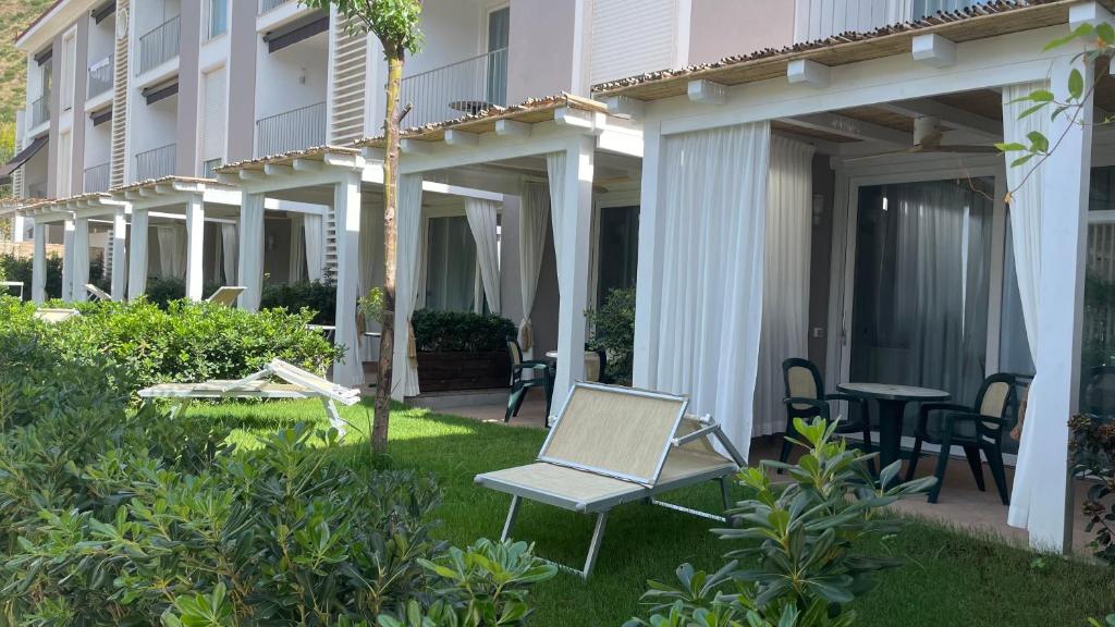a patio with a chair and a table in front of a building at Ancora Resort in Acciaroli