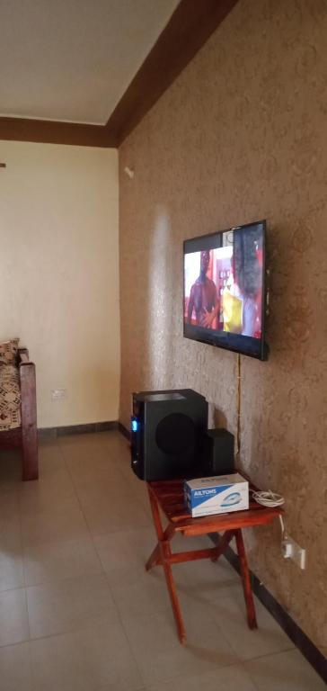 a living room with a tv on a wall at Picho two bedroom apartment in Malindi