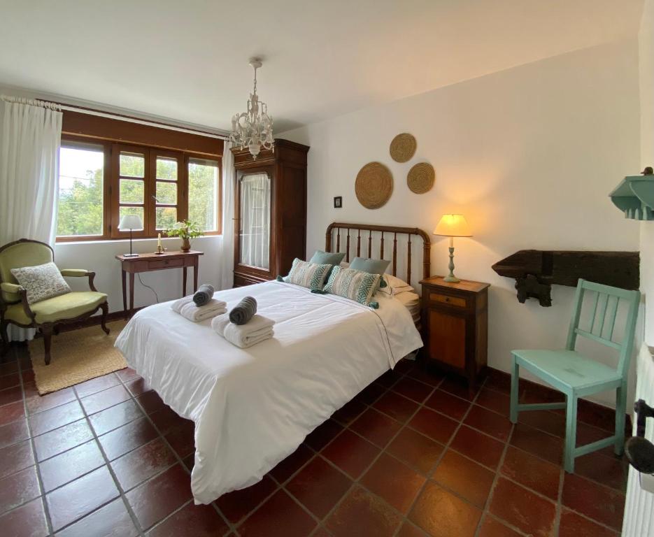 1 dormitorio con 1 cama blanca grande y 1 silla en Casa Buganvilla, Comillas, Cantabria, 