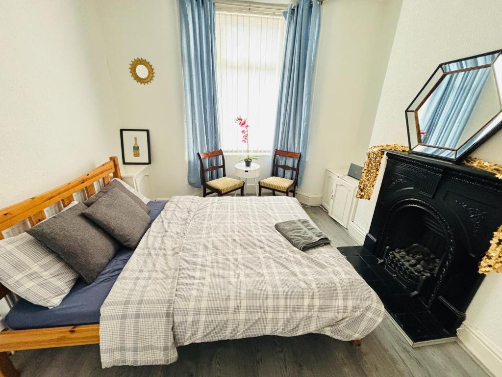 a bedroom with a bed and a fireplace at Entire 3 Bedroom House- FREE PARKING in Liverpool
