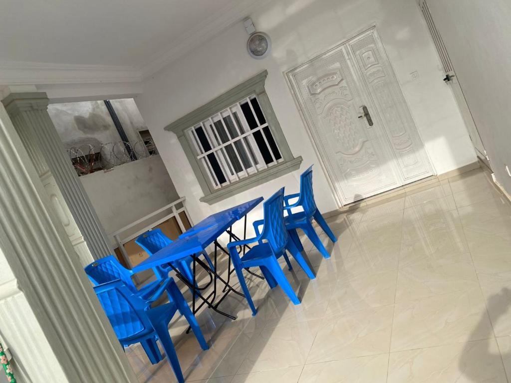 Belle villa à Ségbé في لوميه: مجموعة من الكراسي الزرقاء في غرفة مع باب