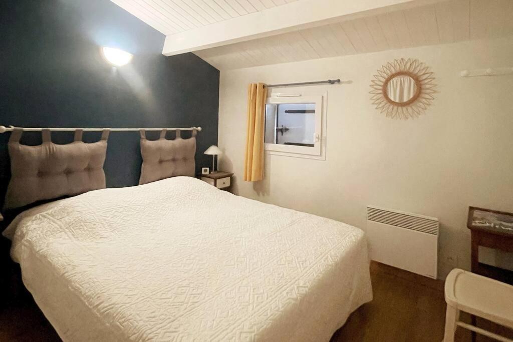 une chambre avec un lit blanc et un miroir dans l'établissement L'authentique - Cosy & Calme, à La Pironnière