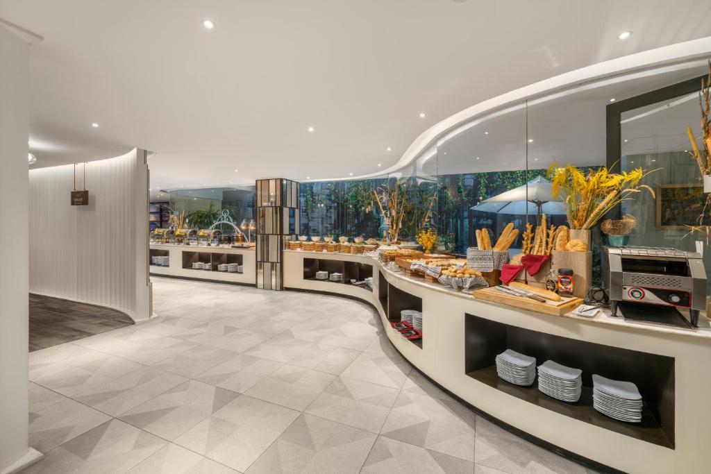 a restaurant with a counter with food on it at Satya Da Nang Hotel Han Market in Danang