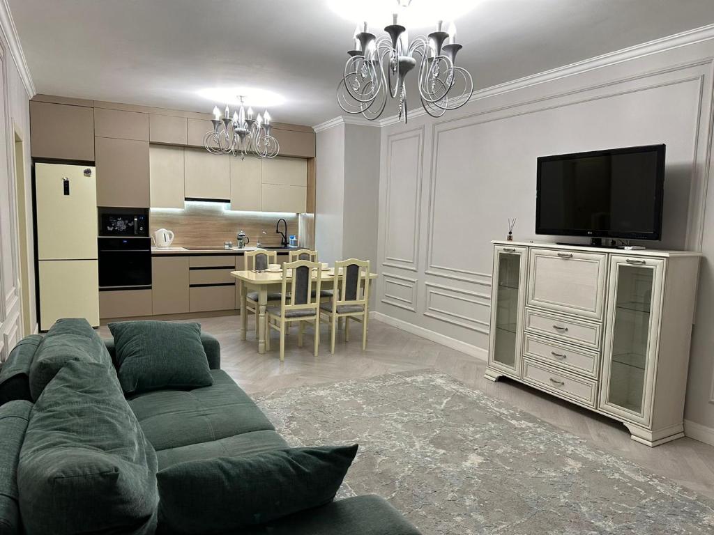 uma sala de estar com um sofá verde e uma cozinha em 2 room ЖК Raiymbek near MEGA, F11 em Almaty