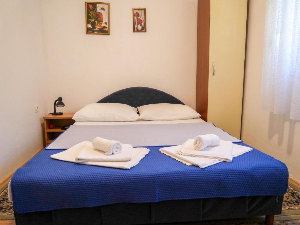 1 dormitorio con 1 cama con toallas en Studio Apartment Maršić en Zaostrog