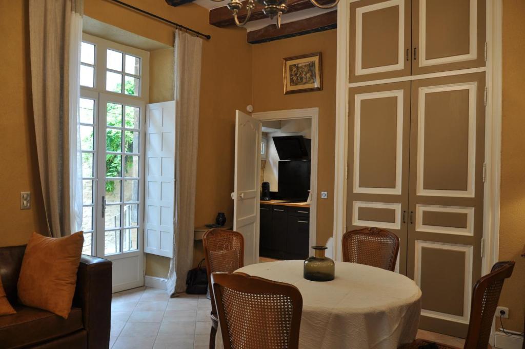 une salle à manger avec une table, des chaises et une télévision dans l'établissement la traverse, à Sarlat-la-Canéda