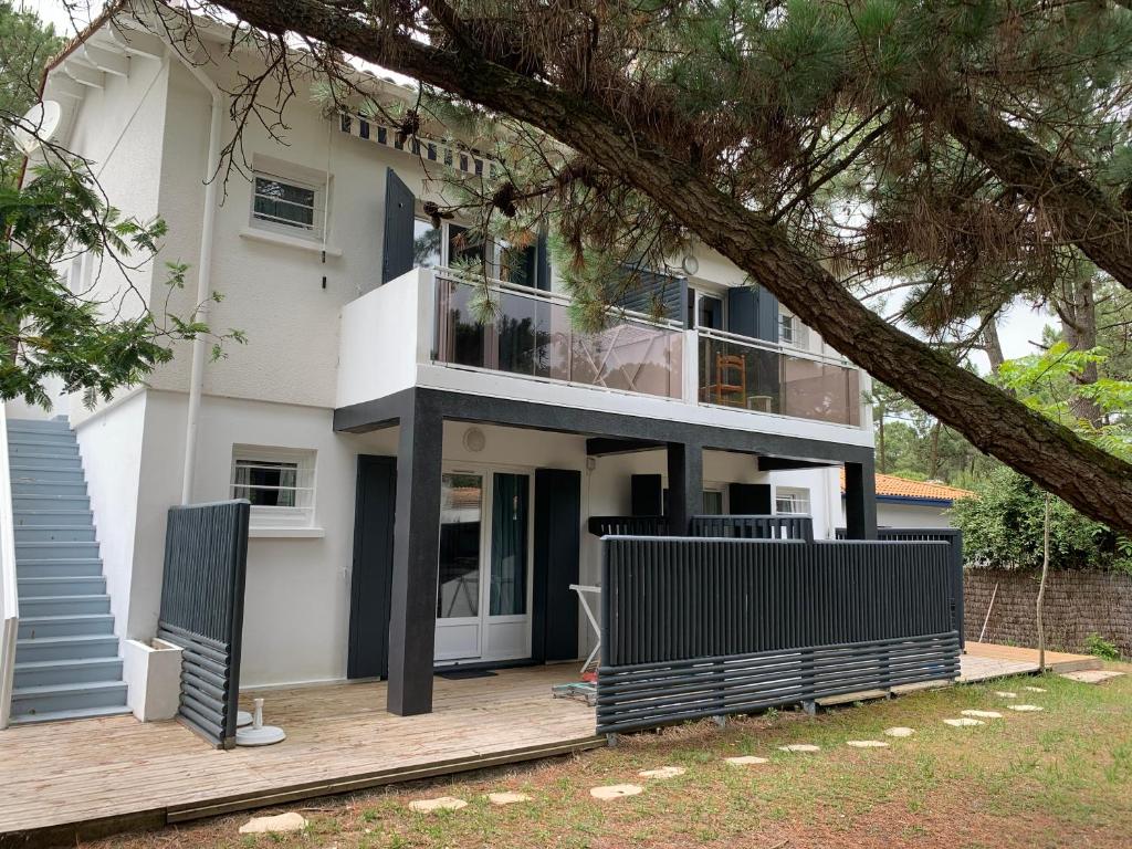 a large white house with a balcony at Les studios de l'Océan in Les Mathes