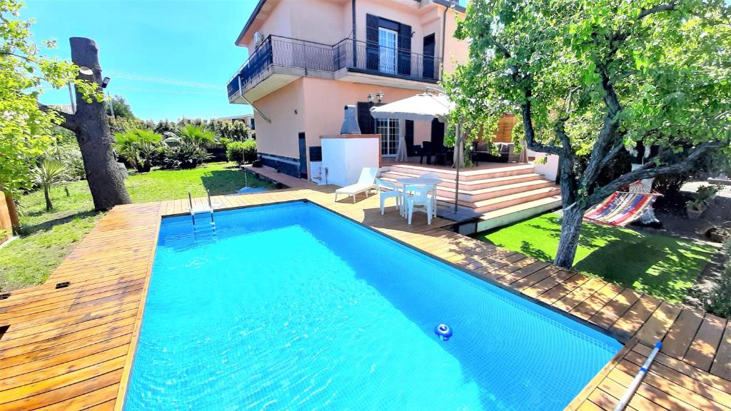 - une piscine en face d'une maison dans l'établissement Villa Etna, à Viagrande