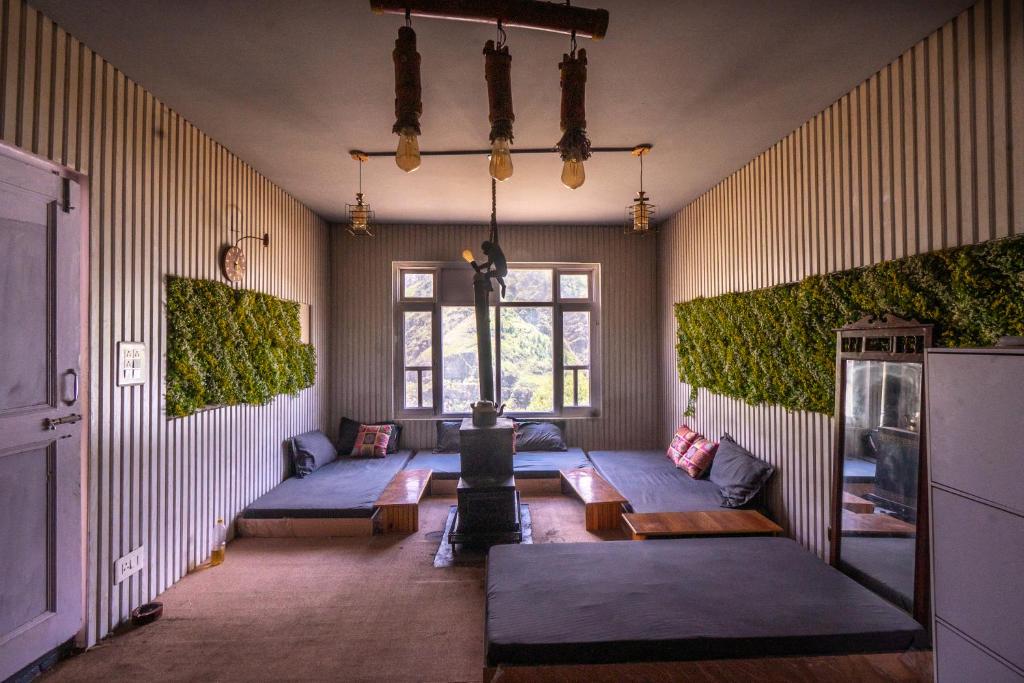 een woonkamer met blauwe banken en een raam bij Grease Moto Club - Khangsar, Sissu in Sissu