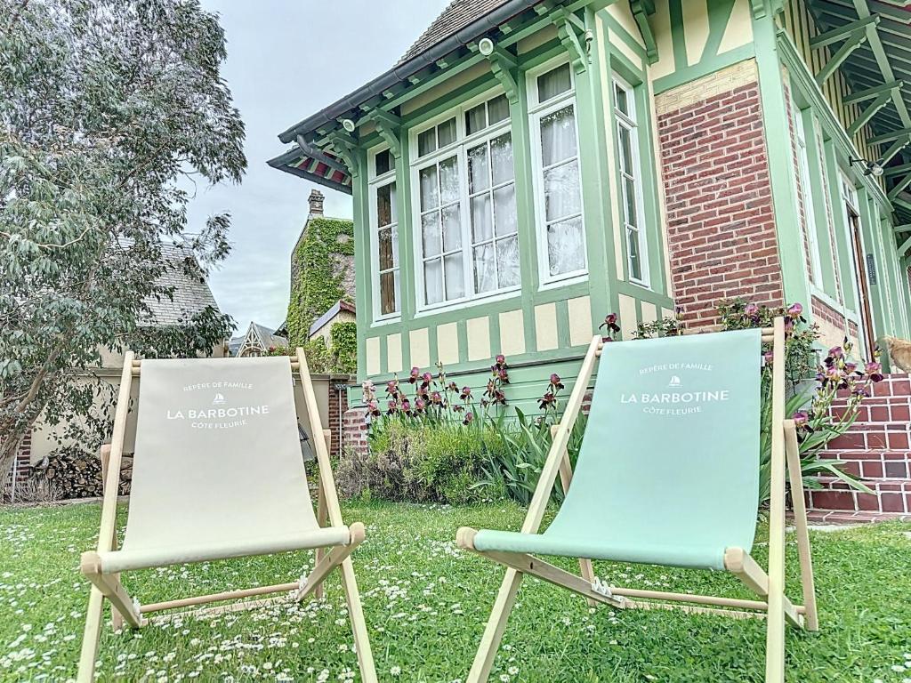 dos sillas de jardín frente a una casa en La Barbotine, maison normande au pied de la plage, en Villers-sur-Mer