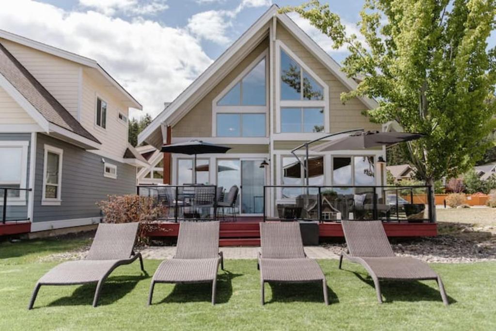 a house with a patio with chairs and an umbrella at Belle Vue Cottage - Kelowna, BC in Kelowna