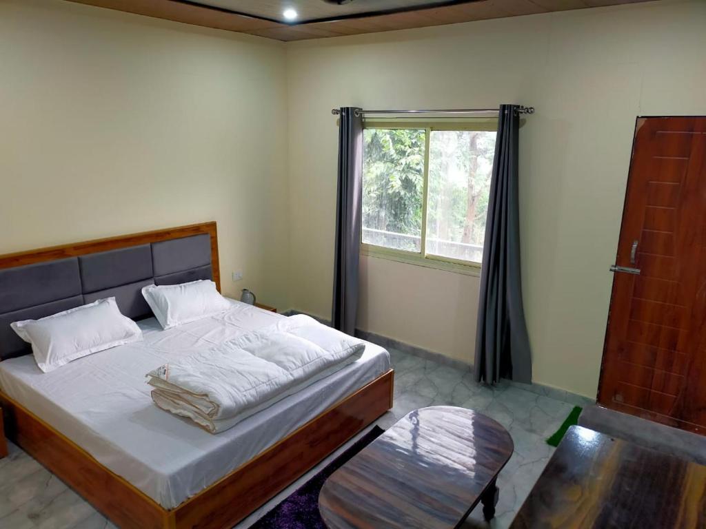 ein Schlafzimmer mit einem großen Bett und einem Fenster in der Unterkunft Trishul Residency in Phata