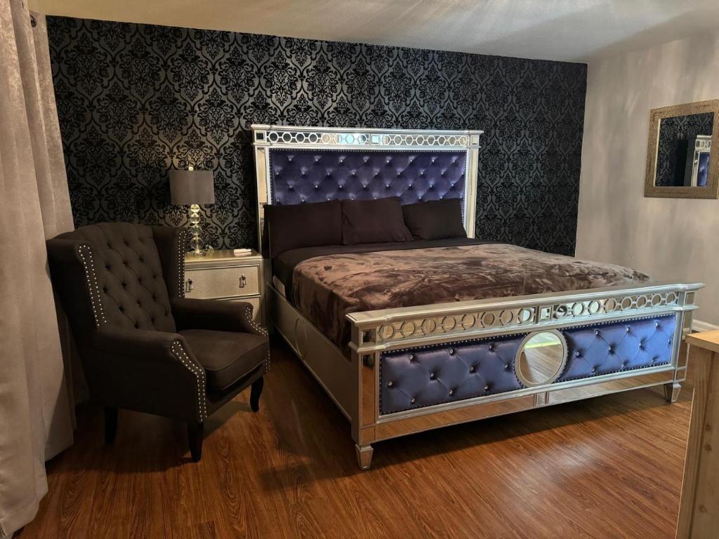 Schlafzimmer mit einem Kingsize-Bett und einem Stuhl in der Unterkunft Red Lotus Inn in Milwaukee