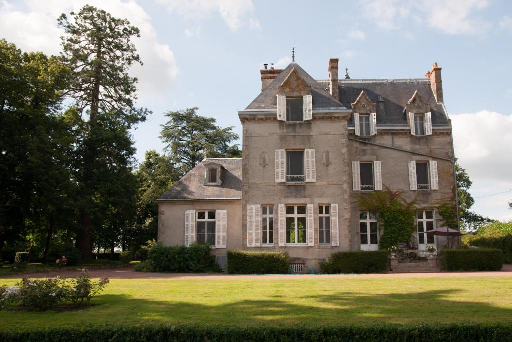 une vieille maison avec une grande cour gazonnée dans l'établissement Château Saint Georges, à Mauléon