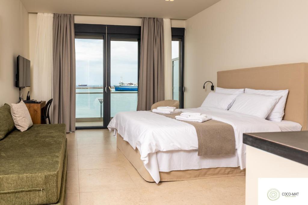 Cette chambre d'hôtel comprend un lit et offre une vue sur l'océan. dans l'établissement Tokyo Studios, à Chios
