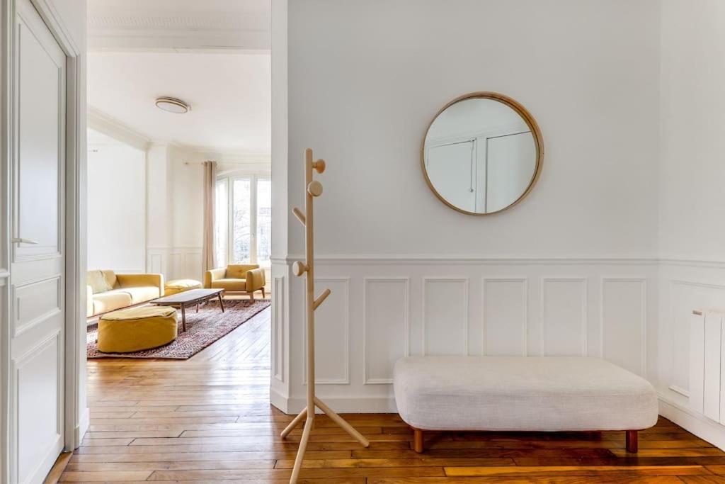 un salon blanc avec un miroir et un pouf dans l'établissement Elegant 2-bedroom appartment in Saint-Denis, à Saint-Denis