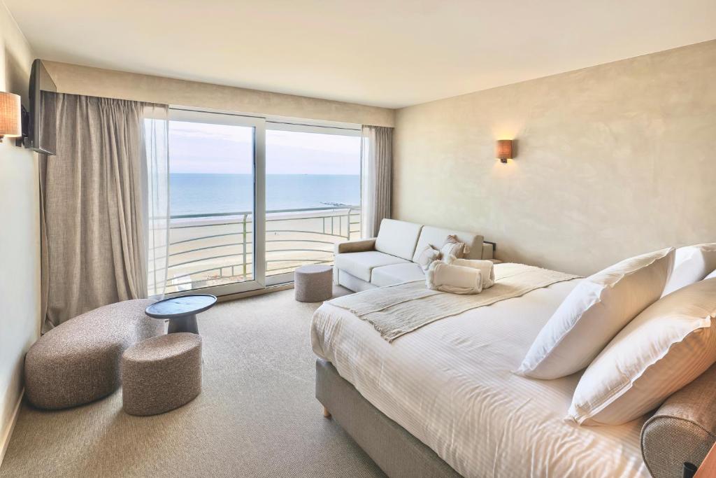 a bedroom with a large bed and a view of the ocean at Hotel Beach Palace in Blankenberge