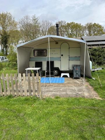 a trailer with a tent in a field at The blue lady in Sleen