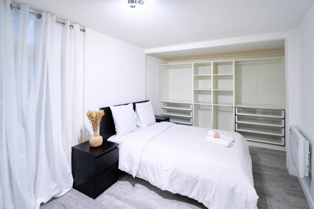 Un dormitorio blanco con una cama blanca y una ventana. en La loge des Carmélites Coeur de Nantes WIFI, en Nantes