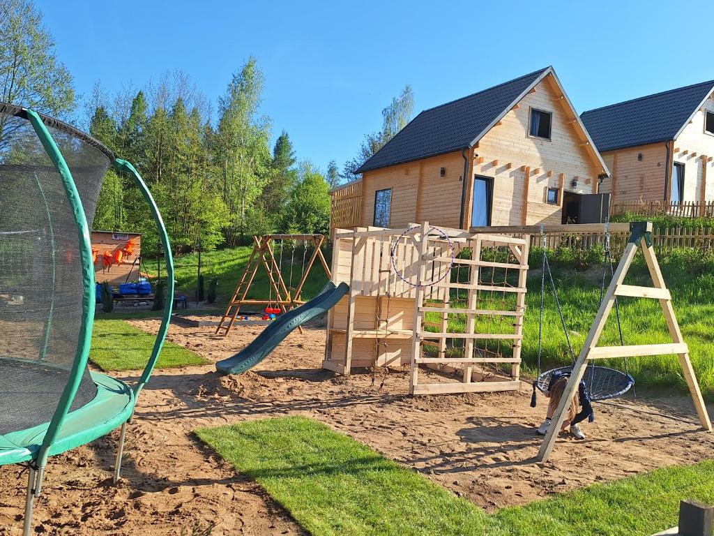 a playground with a slide and a swing set at Domek Na Mazurach in Bogaczewo