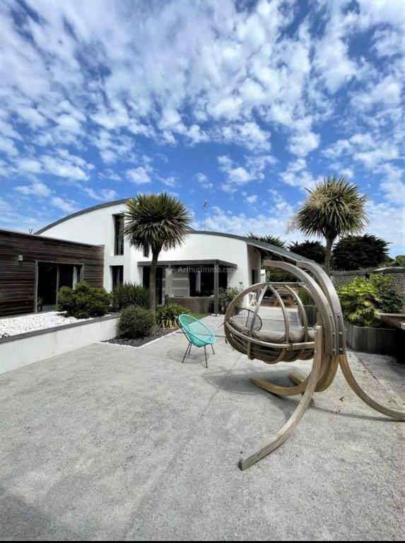 une aire de jeux en face d'un bâtiment avec des palmiers dans l'établissement Summer House Vip, à Saint-Hilaire-de-Riez