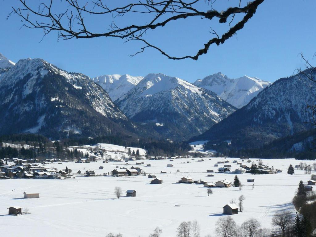 a snow covered village with mountains in the background at Bergnescht in Oberstdorf