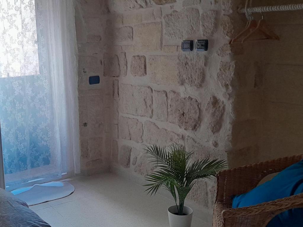 - une chambre dotée d'un mur en pierre et d'une plante en pot dans l'établissement Il Nido al Castello, à Monopoli