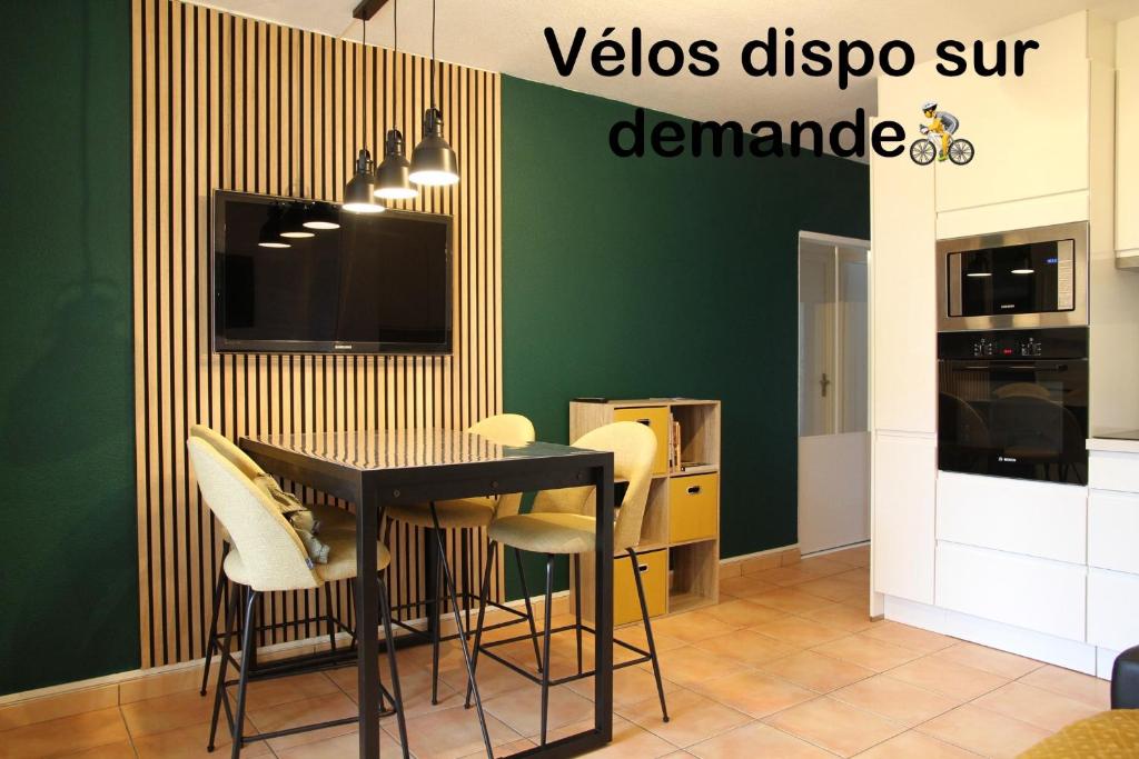 une salle à manger avec une table noire et des chaises blanches dans l'établissement Poziodé, à Courseulles-sur-Mer