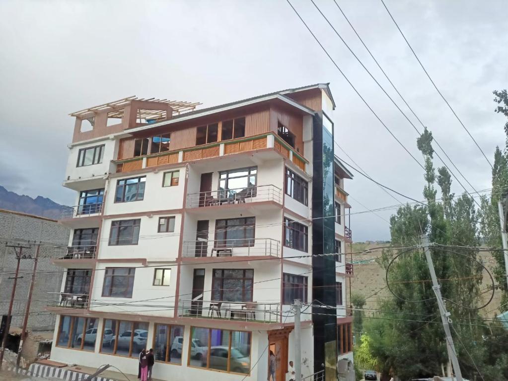 a tall building with people standing in front of it at HOTEL D INDIAN KARGIL in Kargil