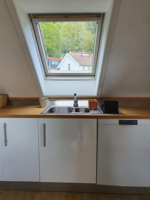 cocina con fregadero y ventana en The Hui Home en Bergen