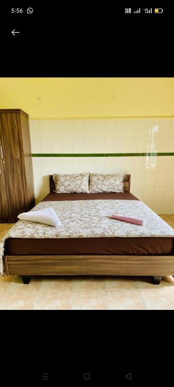 a bed with two pillows on it in a room at LAIBARESIDENCy in Panamaram