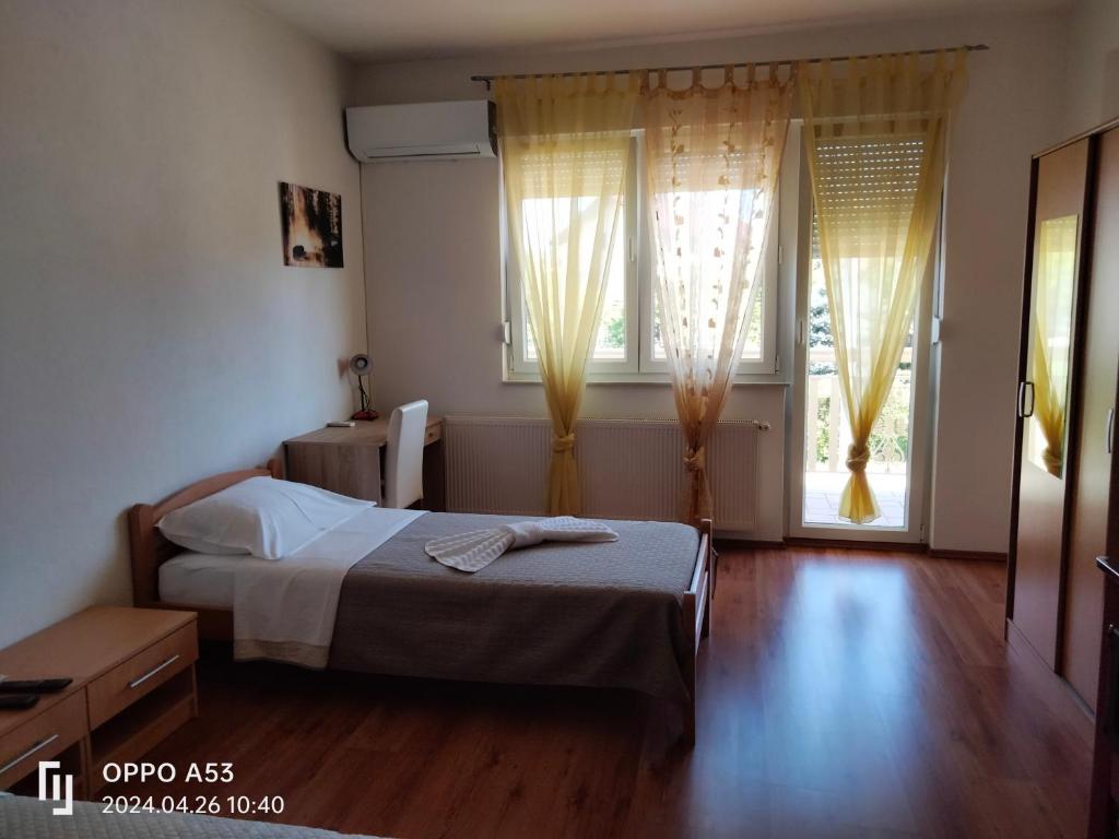 a bedroom with a bed and two windows at Apartman Nikolic,Banja Vrucica,Teslic in Teslić
