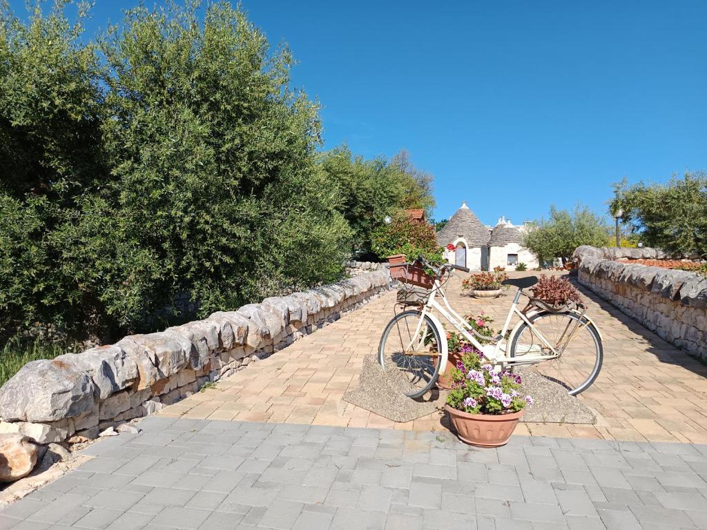 a bike is parked next to a stone wall at La Rosa dei Trulli B&B in Alberobello